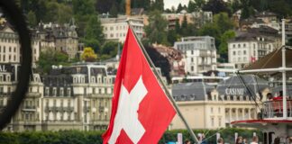 red and white sail boat on water near city buildings during daytime