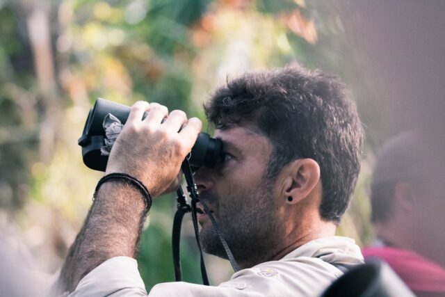 Photo by Forest Simon man using black binoculars at daytime