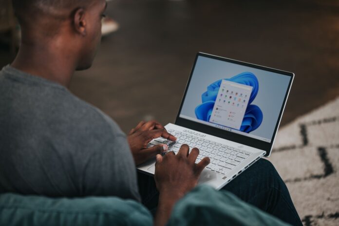 Photo by Windows man in gray long sleeve shirt using Windows 11 computer