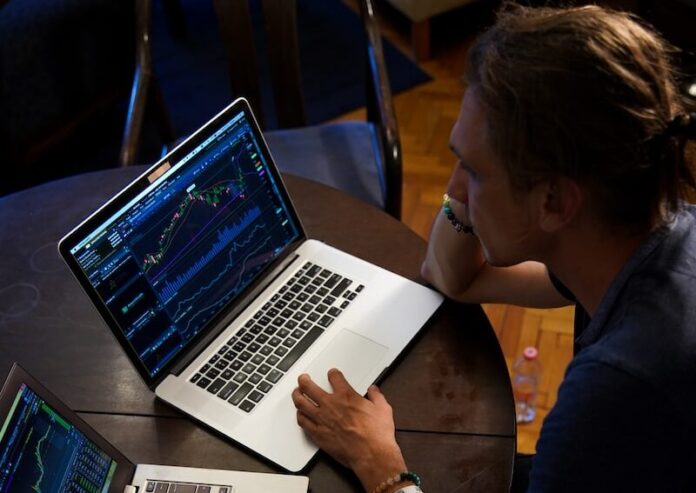 man sitting in front of the MacBook Pro