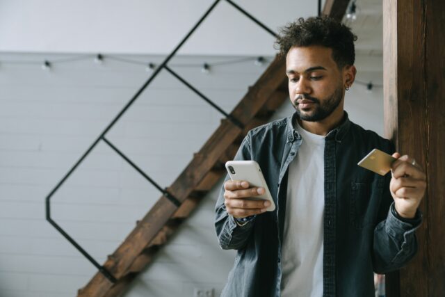 Photo by Ivan Samkov Man Holding Cellphone and a Credit Card