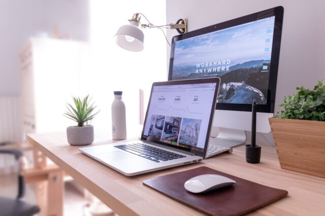 Photo by Domenico Loia MacBook Pro on table beside white iMac and Magic Mouse
