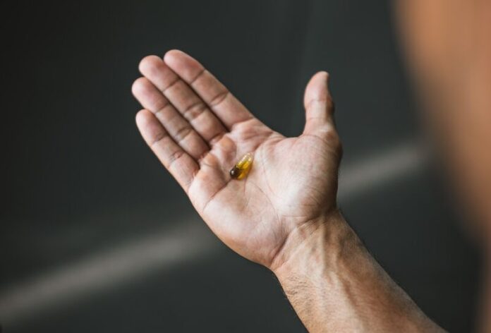 a man holding his hand out with a ring on it