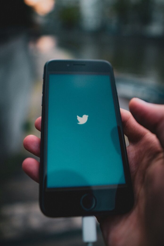 Twitter’s Trust And Safety Head Resigns Amid Anti-Transgender Video Controversy - Twitter News person holding black iphone 5