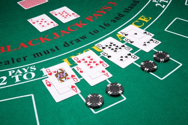 A poker table with cards and chips Description automatically generated