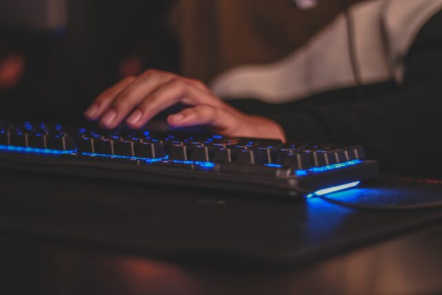 Photo by Axville person holding gaming keyboard
