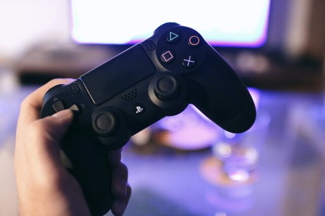 Photo by JÉSHOOTS Person Holding Sony Ps4 Dualshock 4