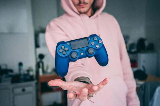 Photo by Florian Gagnepain person holding blue Sony PS4 Dualshock 4 c