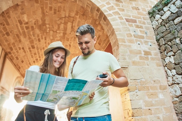 photo-happy-young-couple-of-travellers-holding-map Photo happy young couple of travellers holding map in hands
